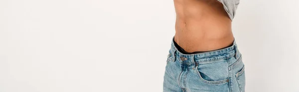 Panoramic shot of muscular mixed race man undressing on white — Stock Photo