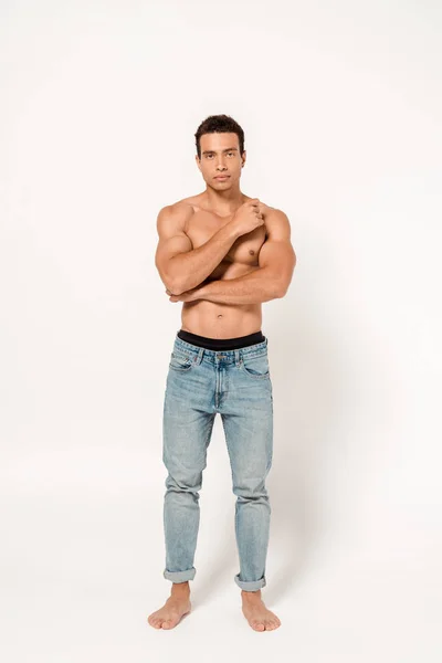 Handsome and shirtless mixed race man standing and looking at camera on white — Stock Photo