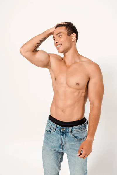 Happy and shirtless mixed race man touching hair while standing on white — Stock Photo