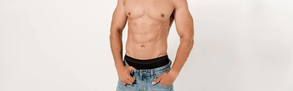 Plan panoramique de sexy homme de race mixte torse nu debout avec la main dans la poche sur blanc — Photo de stock