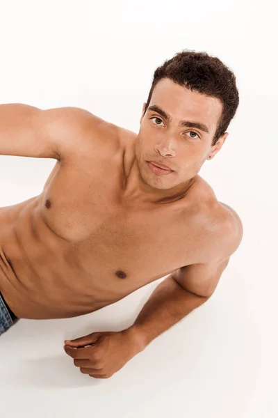 Handsome and shirtless bi-racial man looking at camera on white — Stock Photo