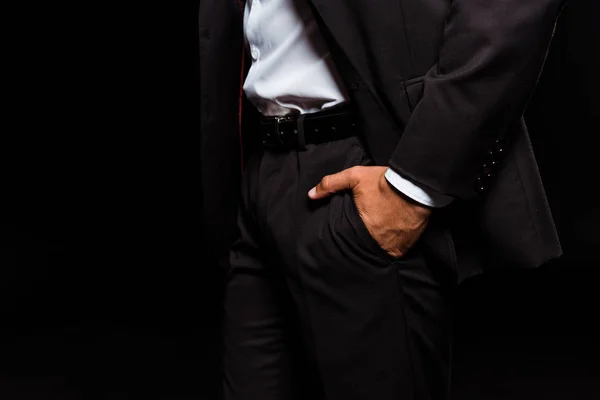 Cropped view of mixed race man standing with hand in pocket isolated on black — Stock Photo