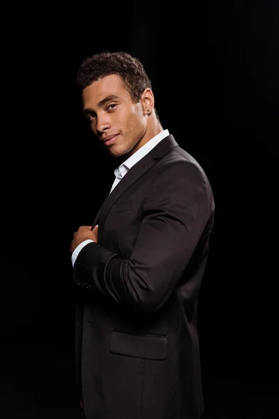 Щасливий чоловік змішаної раси дивиться на камеру ізольовано на чорному — стокове фото