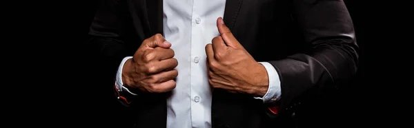 Panoramic shot of bi-racial man touching suit isolated on black — Stock Photo
