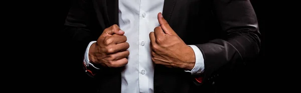 Plano panorámico del hombre bi-racial tocando traje aislado en negro - foto de stock