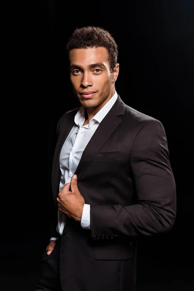 Cheerful mixed race man looking at camera isolated on black — Stock Photo
