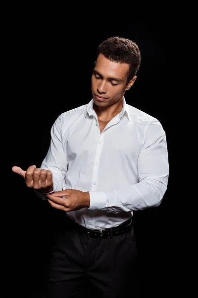 Beau mixte homme toucher chemise blanche isolé sur noir — Photo de stock
