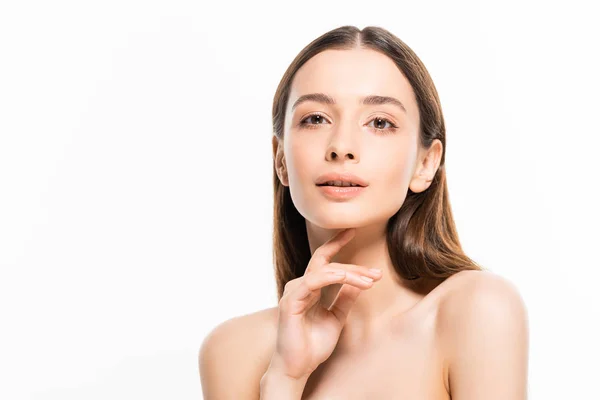 Beautiful young naked woman with perfect skin looking at camera while touching chin isolated on white — Stock Photo
