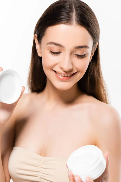 Jovem feliz com pele perfeita segurando creme cosmético isolado no branco — Fotografia de Stock