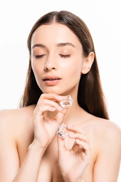 Jovem mulher nua morena com pele perfeita e olhos fechados segurando cubos de gelo isolados em branco — Fotografia de Stock