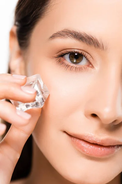 Vue rapprochée de belle brune jeune femme avec une peau parfaite tenant glaçon isolé sur blanc — Photo de stock