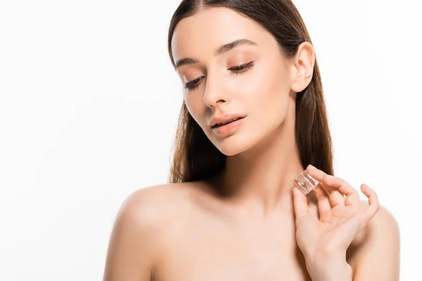 Beautiful brunette young naked woman with perfect skin holding ice cube and looking down isolated on white — Stock Photo