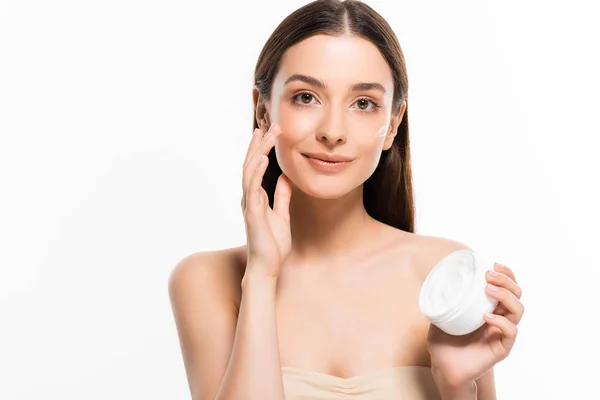 Bella donna sorridente con pelle perfetta applicare crema cosmetica sul viso isolato su bianco — Foto stock
