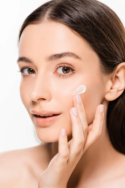 Schöne junge Frau mit perfekter Haut Anwendung kosmetischer Creme auf Gesicht isoliert auf weiß — Stockfoto