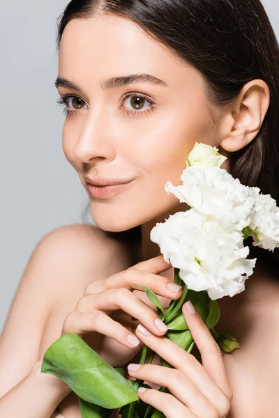 Sonriente hermosa chica morena con claveles blancos aislados en gris — Stock Photo