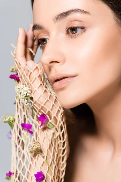 Portrait de belle femme en maille avec des fleurs violettes isolées sur gris — Photo de stock