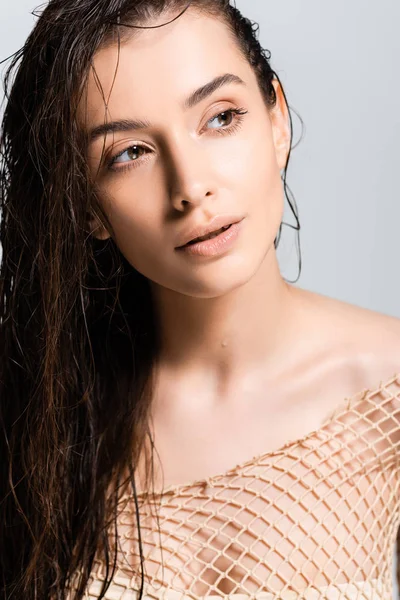 Beautiful woman with wet hair in mesh beige clothing looking away isolated on grey — Stock Photo