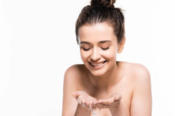 Mujer morena joven desnuda feliz con belleza natural lavándose con agua limpia en palmas aisladas en blanco - foto de stock