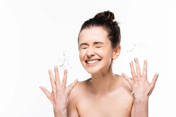 Glücklich nackte junge brünette Frau mit natürlicher Schönheit Abwaschen mit sauberem Wasser Spritzer und gestikulieren isoliert auf weiß — Stockfoto