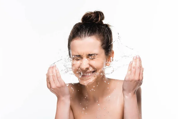 Щаслива гола молода брюнетка з природною красою, що миється з чистими бризками води ізольована на білому — стокове фото