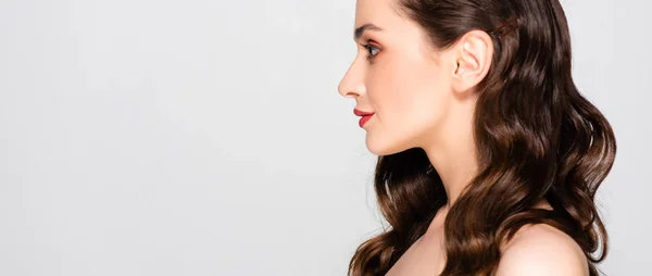 Profile of naked beautiful brunette woman with curls and makeup isolated on grey, panoramic shot — Stock Photo