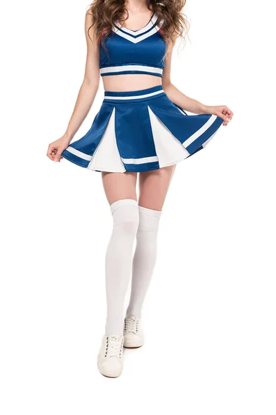 Cropped view of sexy cheerleader girl in blue uniform holding skirt isolated on white — Stock Photo