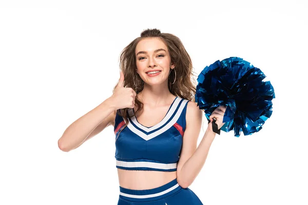 Alegre cheerleader menina em azul uniforme segurando pompom e mostrando polegar para cima isolado no branco — Fotografia de Stock