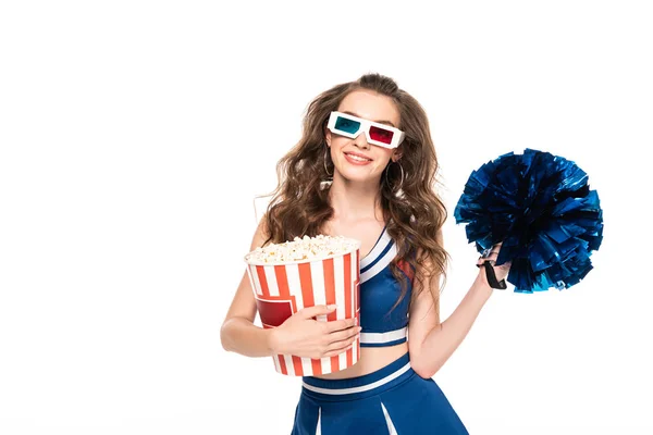 Lächelndes Cheerleader-Mädchen in blauer Uniform und 3D-Brille mit Bommel und Eimer Popcorn isoliert auf weiß — Stockfoto