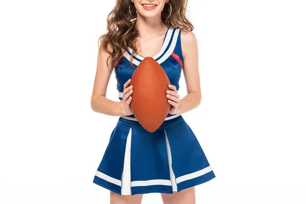 Обрізаний вид щасливої дівчини-вболівальниці в синій формі тримає м'яч регбі ізольований на білому — стокове фото