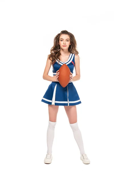 Piena vista lunghezza della ragazza sexy cheerleader in uniforme blu con palla da rugby isolato su bianco — Foto stock