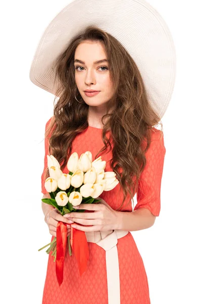 Elegante mujer joven en sombrero y vestido con tulipanes aislados en blanco - foto de stock