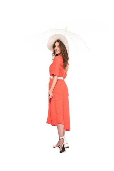Full length view of happy elegant woman in hat and dress holding transparent umbrella isolated on white — Stock Photo