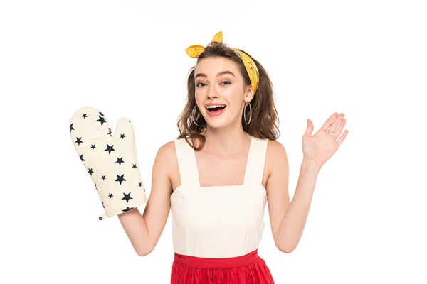 Young excited housewife in dress and apron holding oven mitten isolated on white — Stock Photo