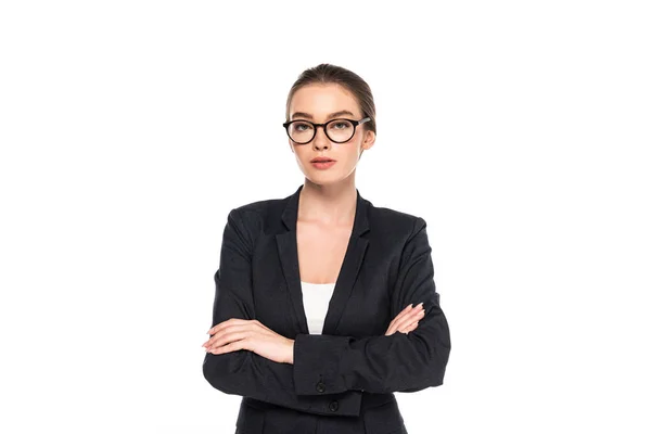 Молода успішна бізнес-леді в чорному костюмі і окулярах з схрещеними руками ізольовані на білому — стокове фото