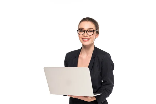 Jeune femme d'affaires heureuse en costume noir et lunettes tenant ordinateur portable isolé sur blanc — Photo de stock