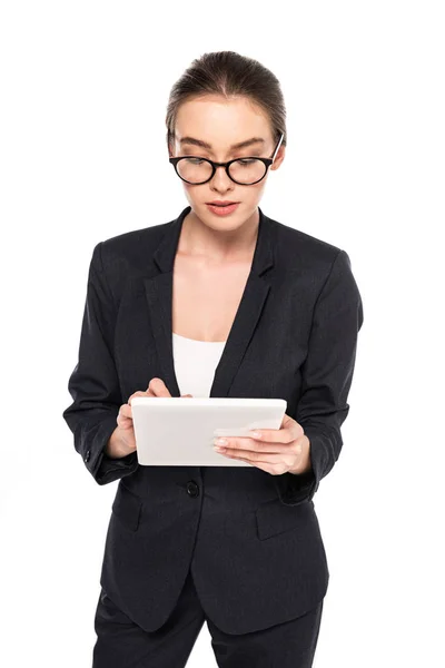 Молода успішна бізнес-леді в чорному костюмі і окулярах з використанням цифрового планшета ізольована на білому — стокове фото