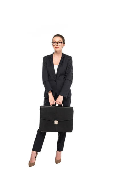 Full length view of young businesswoman in black suit and glasses with briefcase isolated on white — Stock Photo