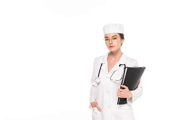Молодий лікар у білому пальто зі стетоскопом та папкою ізольовані на білому — стокове фото