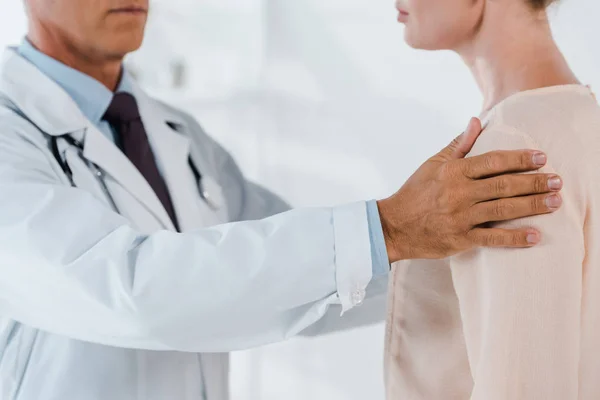 Cropped view of doctor examining woman in clinic — Stock Photo