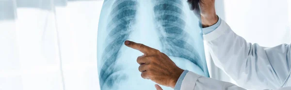 Tiro panorâmico de homem apontando com o dedo em raio-x na clínica — Fotografia de Stock