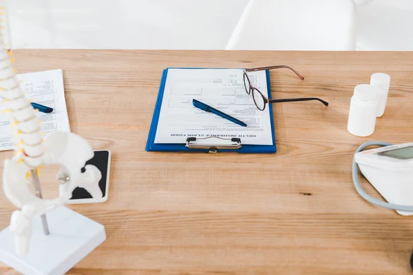 Selective focus of clipboard near pen and glasses in clinic — Stock Photo