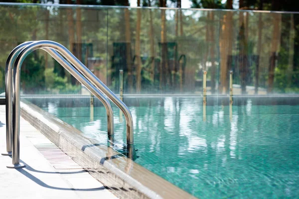 Прозрачный бассейн с перилами на курорте в дневное время — стоковое фото