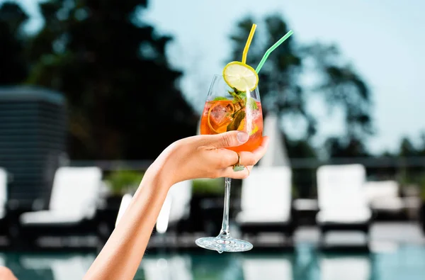 Vista ritagliata della donna che tiene cocktail con menta e limone sul resort — Foto stock