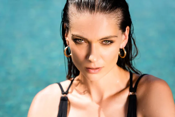 Attractive sexy young woman in swimming suit looking at camera in pool — Stock Photo