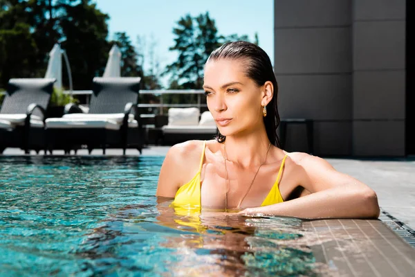 Bela mulher sexy no maiô relaxante na piscina no resort — Fotografia de Stock