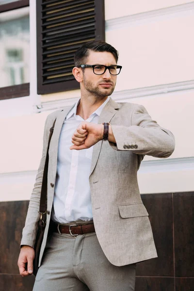 Geschäftsmann mit Brille und Armbanduhr schaut auf der Straße weg — Stockfoto