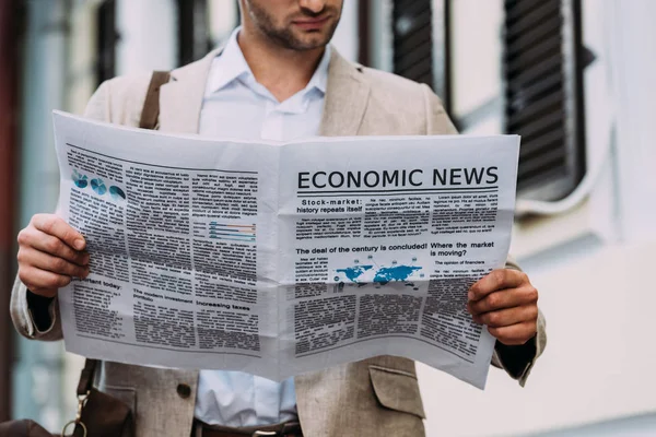 Recortado vista del hombre leyendo el periódico en la calle - foto de stock