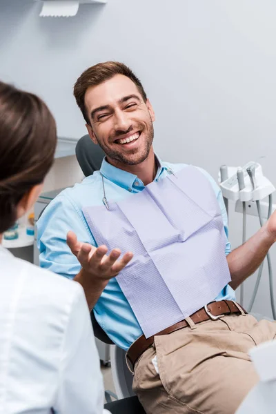 Foco seletivo de gestos pacientes alegres e olhar para o dentista — Fotografia de Stock