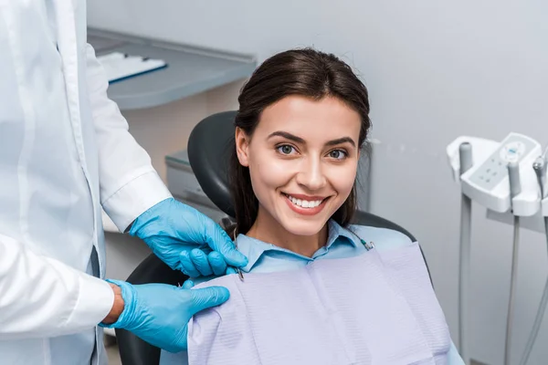 Cropped view of man in latex gloves near happy woman — Stock Photo