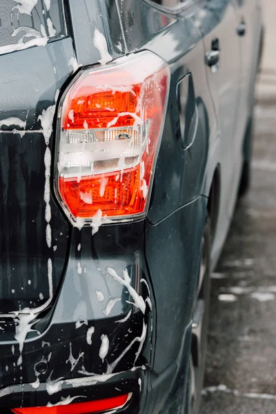 Selective focus of luxury black automobile in car wash — Stock Photo